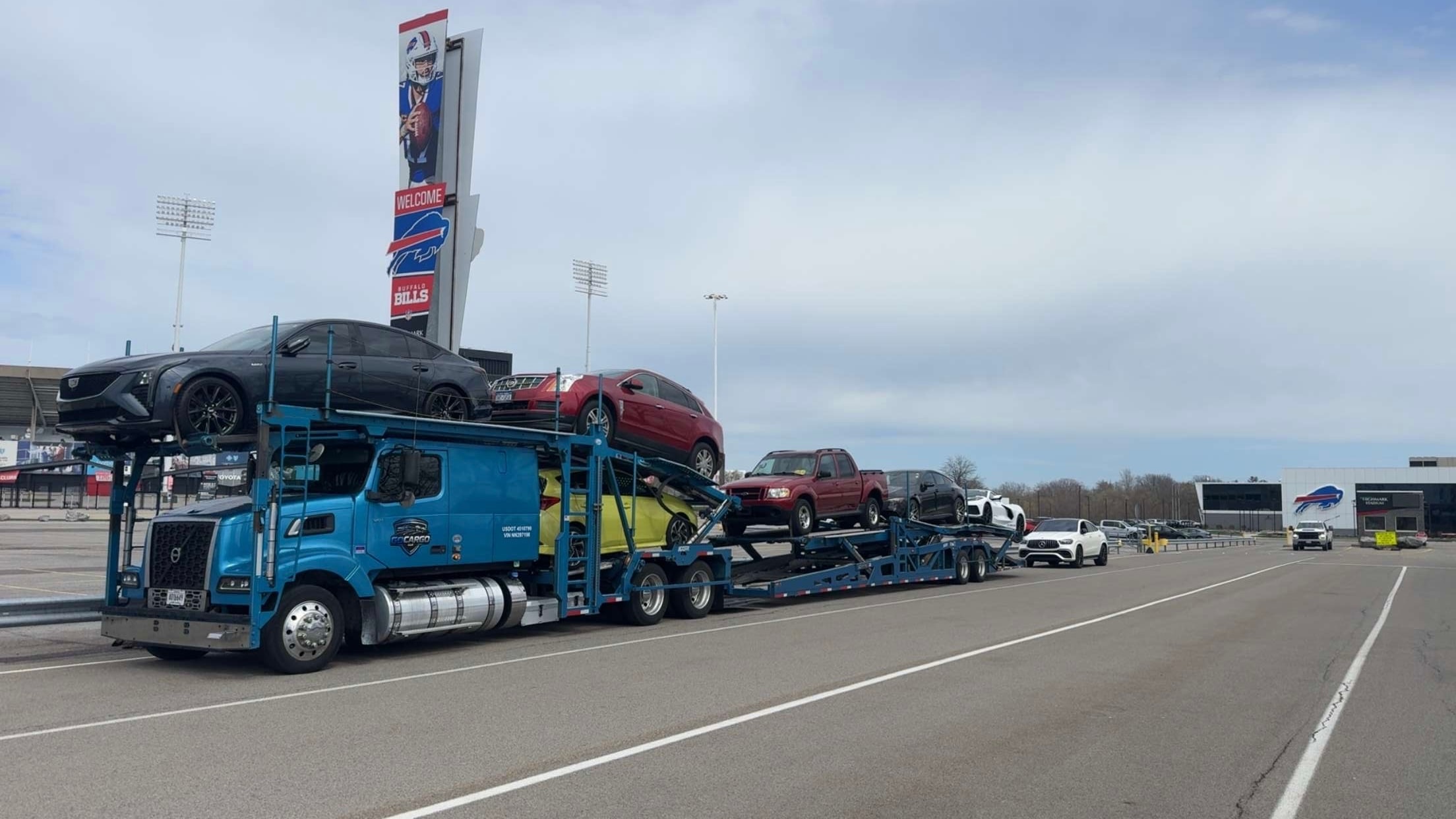 GOCARGO blue car carrier truck at Buffalo Bills stadium parking lot during the day